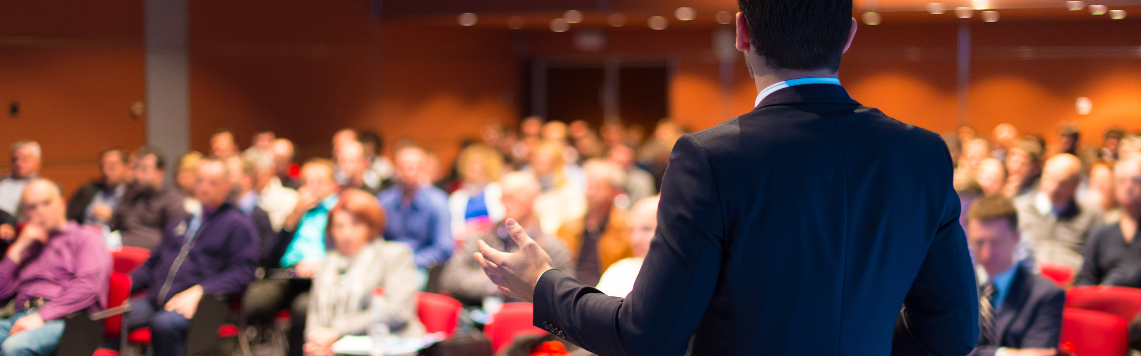 photo of speaker in front of a crowd