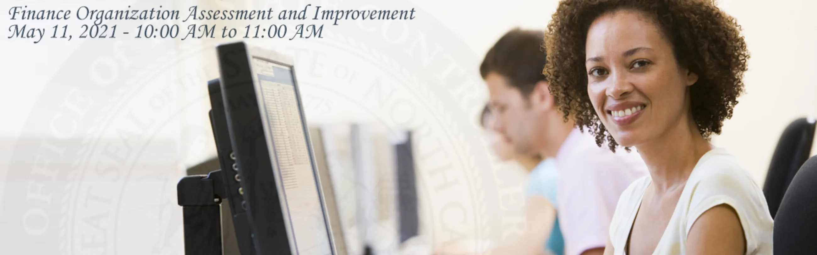 Stock Image: Woman smiles in front of a computer